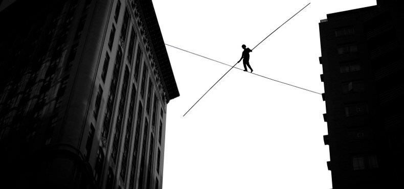 tightrope walker going between city buildings, shows balance between employee autonomy and accountability