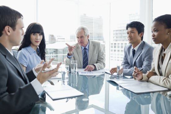 business people at a meeting passing blame