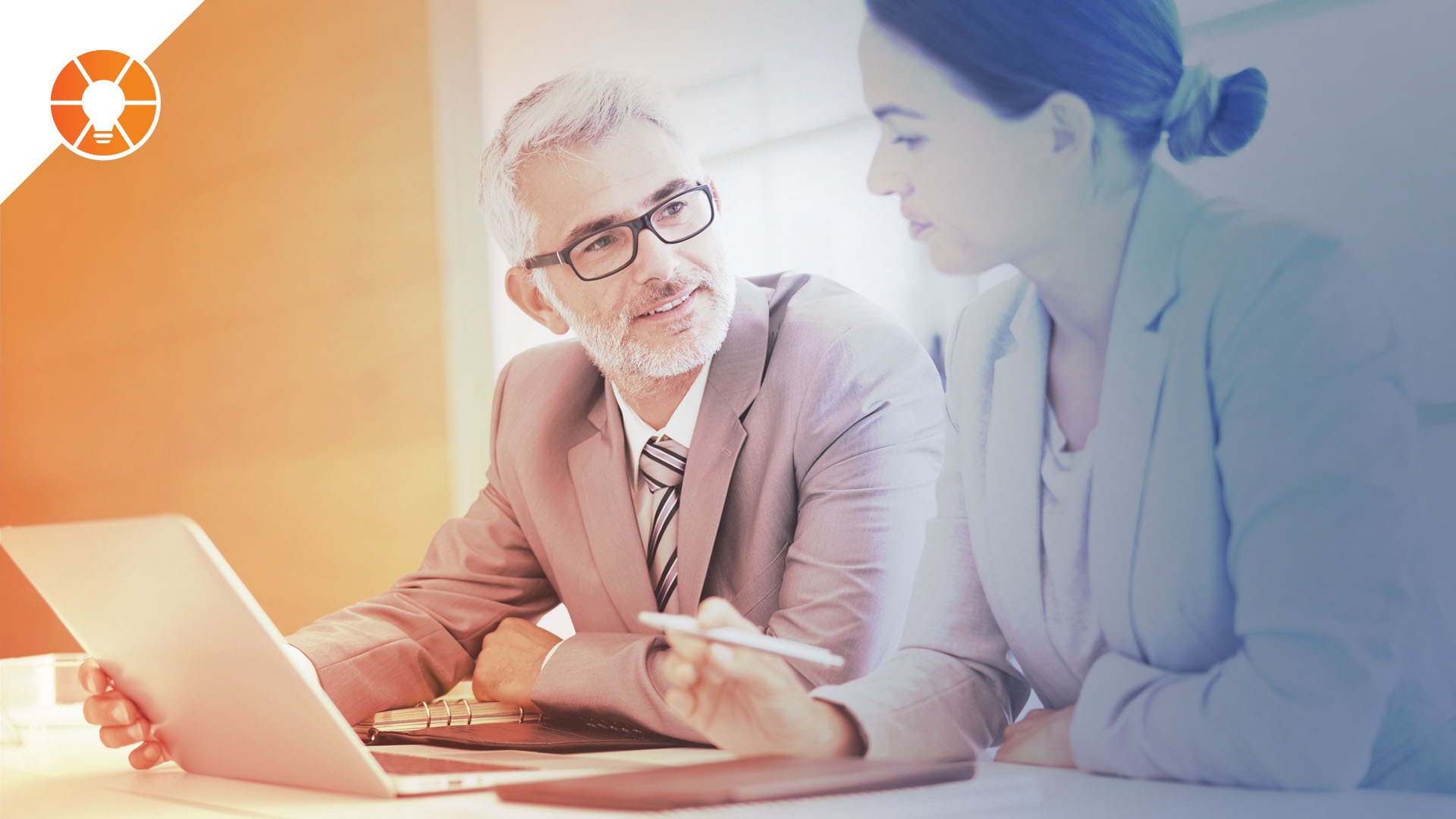 Two people discussing work at a desk