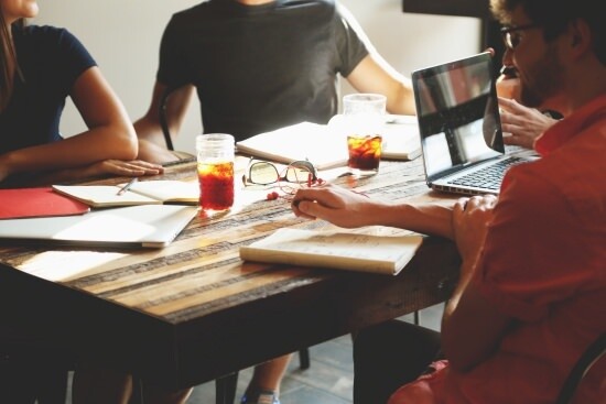 coworkers gathered around a table for a meeting