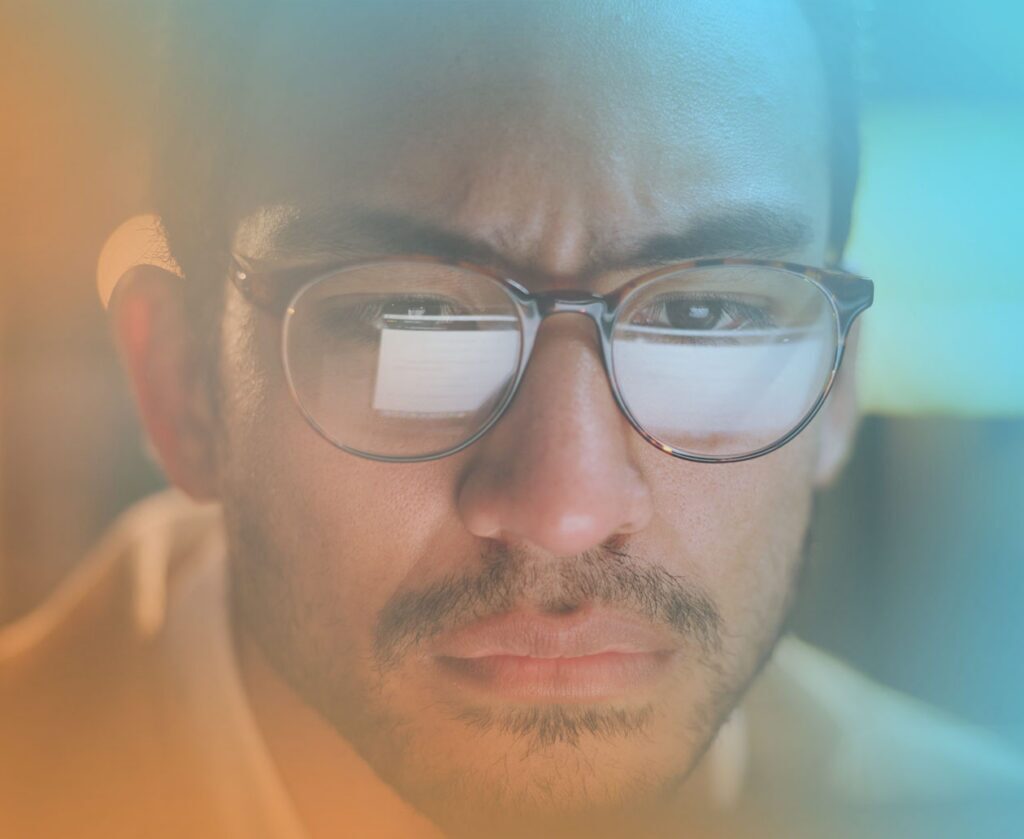 Close-up of a professional wearing glasses and concentrating on a computer screen.