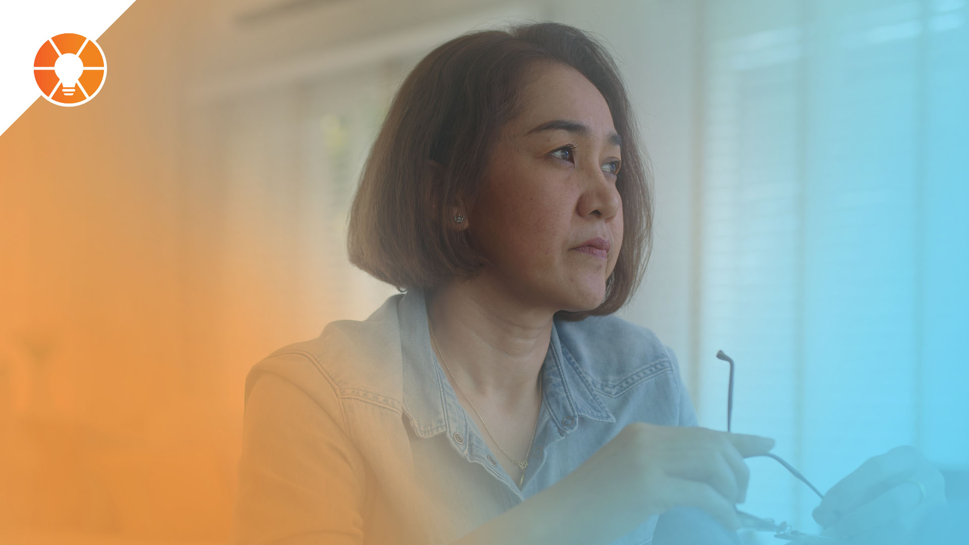 Entrepreneur sitting at a desk holding glasses and looking out the window, appearing overwhelmed and deep in thought about business challenges and burnout.