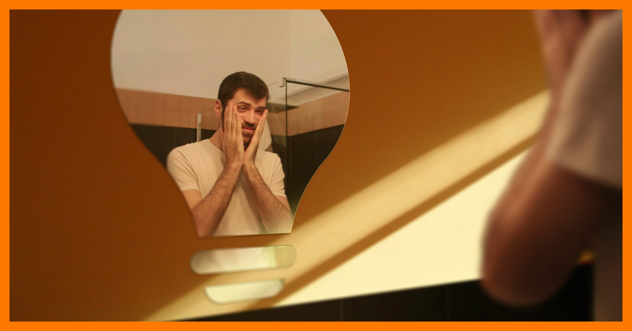 Man looking in Lightbulb shaped mirror with pensive look on his face.
