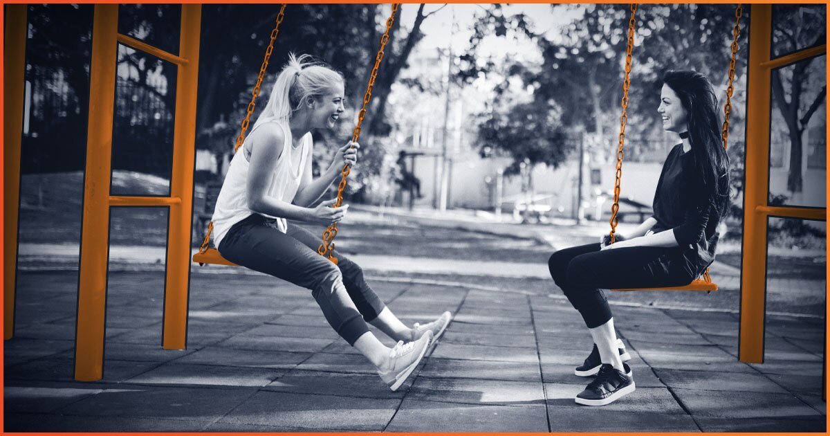 Two woman sitting on swings and talking