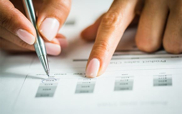 Individual's hands filling in a scorecard