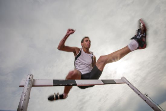 Runner jumping over a hurdle | tips to beat business obstacles