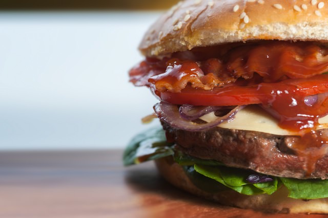 closeup of large hamburger with many toppings | too many business goals