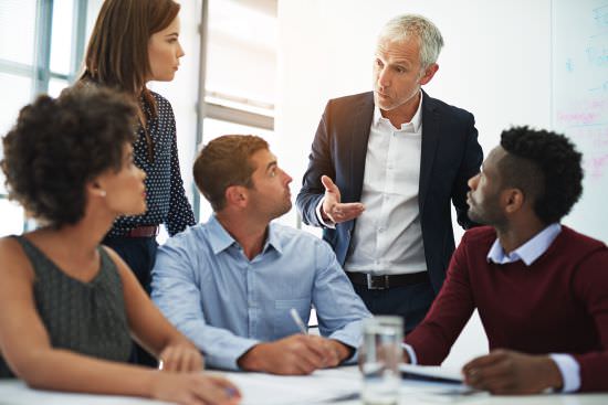 business leader talking with a group of young businesspeople 