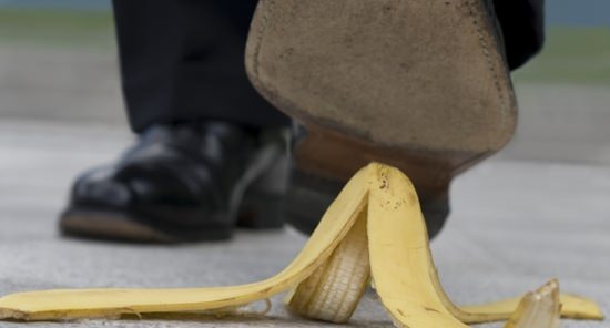 closeup of businessman's shoe about to step on a banana peel