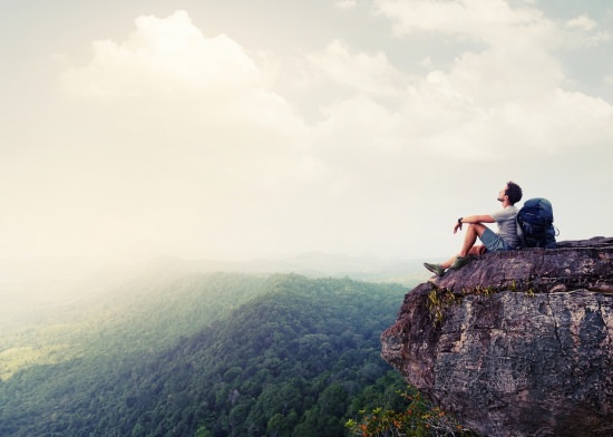 backpacker resting on an outcropping, illustrates the power of delegating