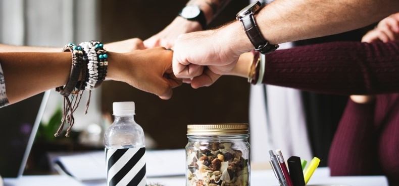 closeup of coworkers fist-bumping | improve your team dynamics