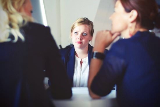 Female boss listening to two employees 