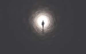 man getting out of a dark tunnel toward light