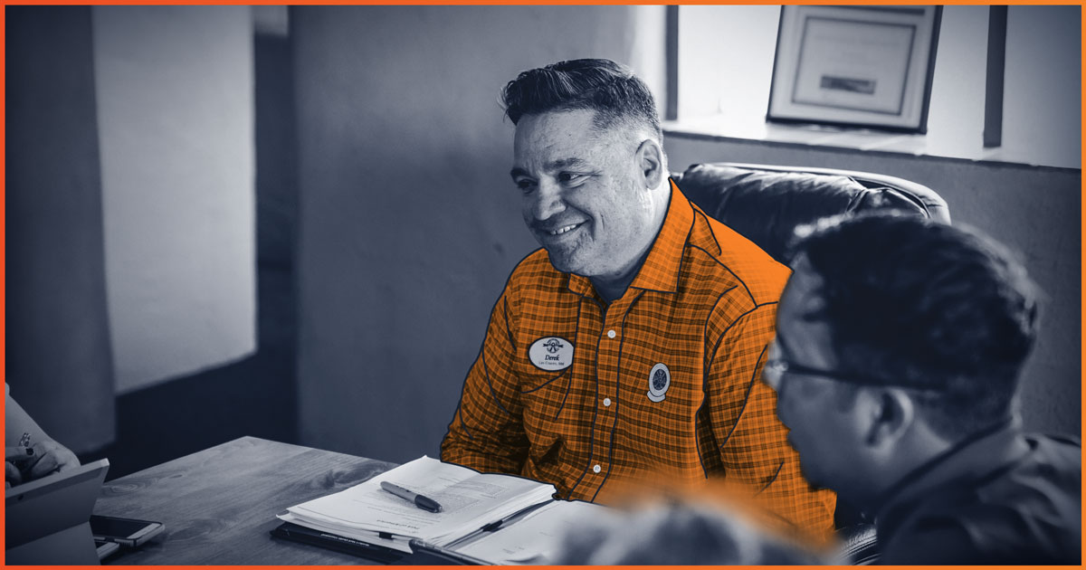 Man in orange in a team meeting