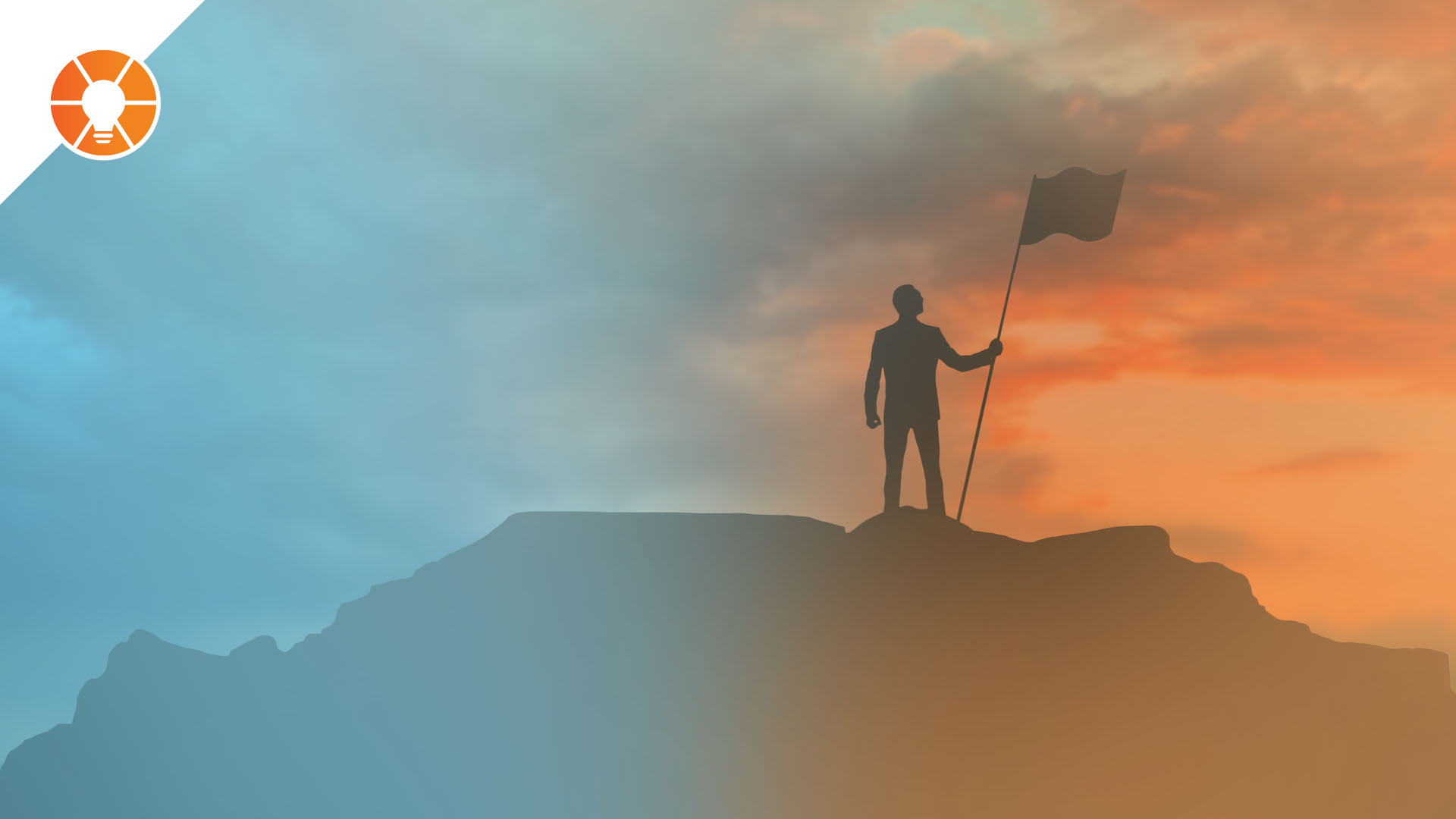 Person standing at top of mountain holding a flag at sunset