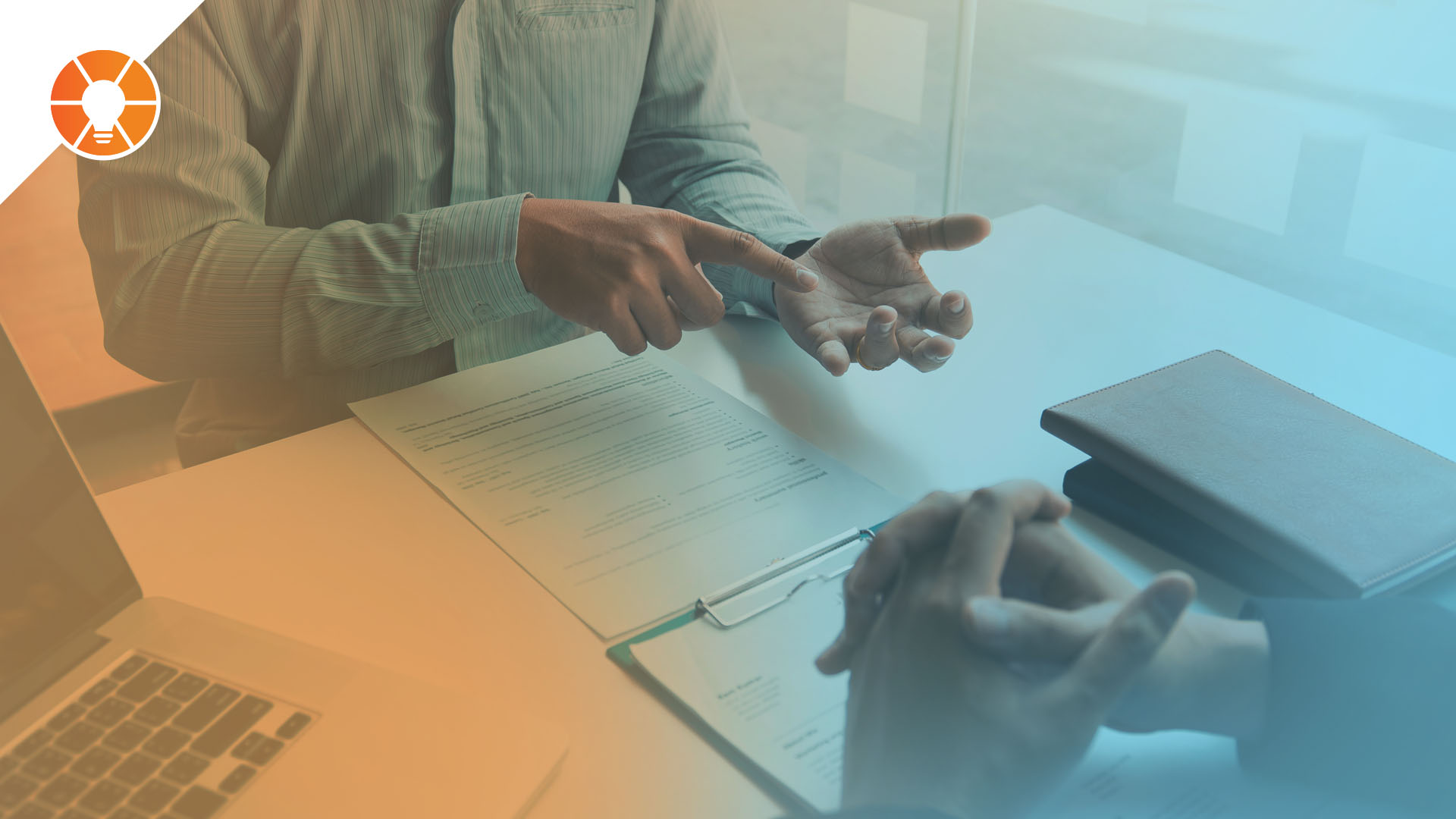 Two people meeting at a business table having a discussion using hand gestures