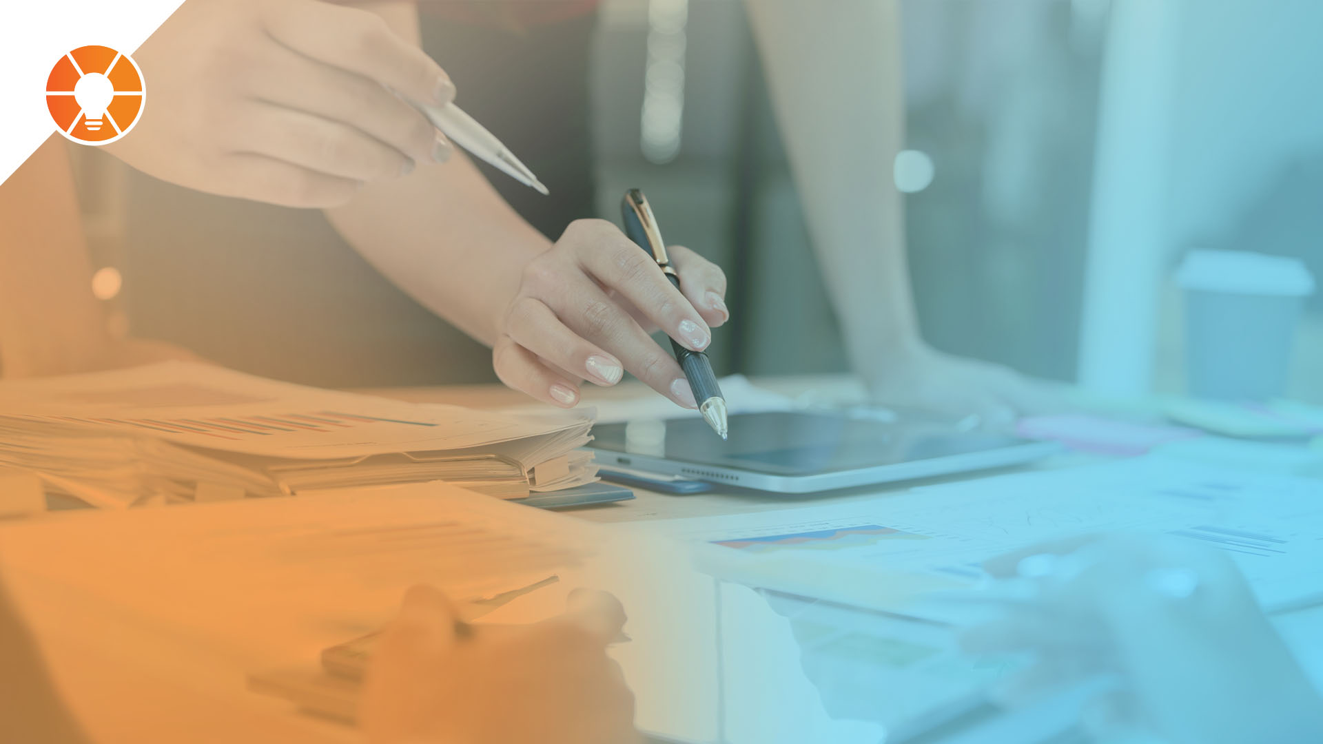 Hands of business professionals collaborating over documents and a tablet, representing strategic planning and long-term goal setting