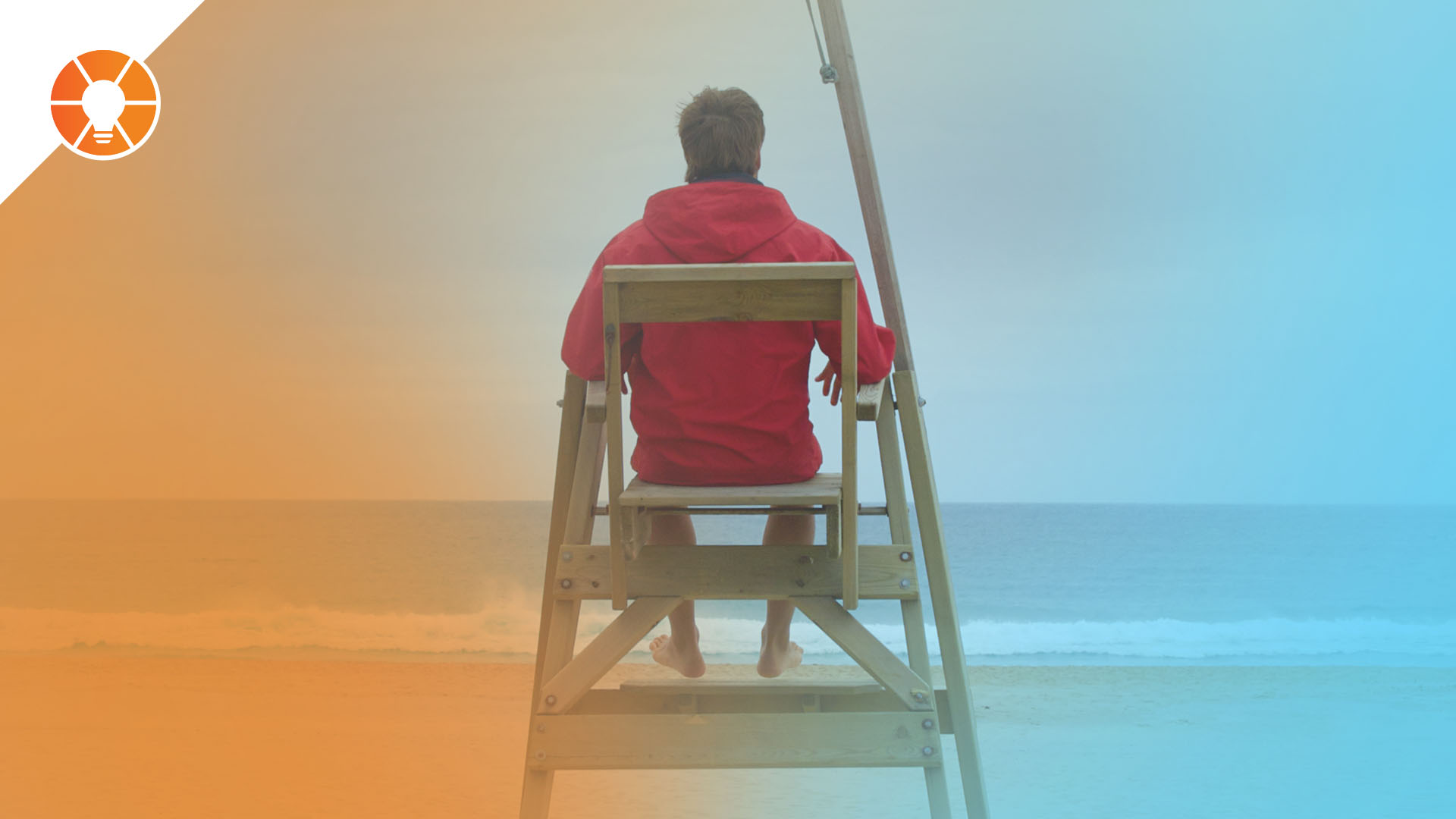 Person in a red jacket sitting in a lifeguard chair facing the ocean, symbolizing oversight and a clear vantage point for monitoring activity.