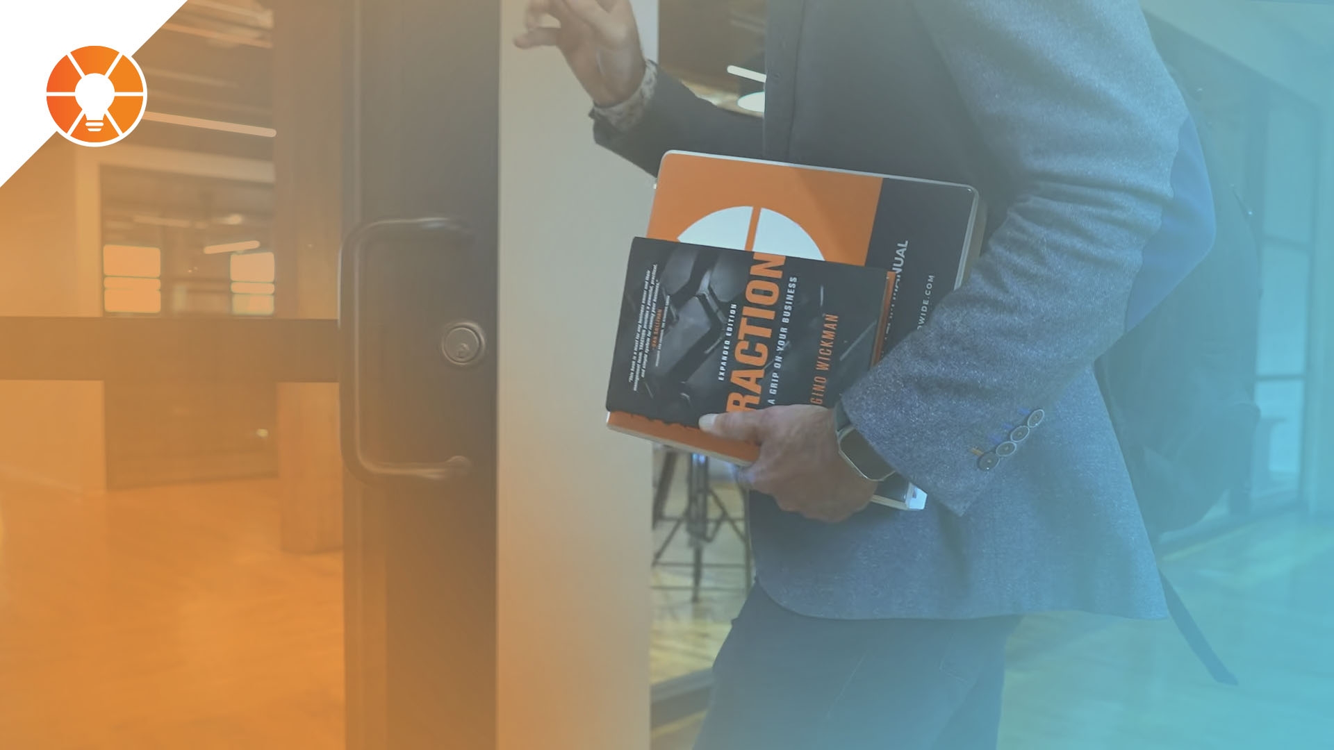 An entrepreneur walks through a door with Traction by Gino Wickman under their arm